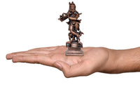 Small dark bronze Krishna idol on square base held in hand for scale