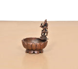Krishna urli bowl showpiece side view, scalloped copper basin with central deity figure