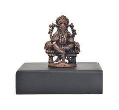 Copper Lord Ganesha idol front view on square dark pedestal base