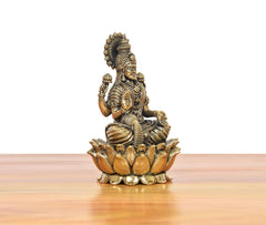 Angled view bronze Lakshmi statue on lotus base, detailed arms, belt, and jewelry.