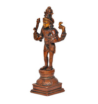 Brass Lord Shiva idol side view, four arms holding small emblems, ornate crown