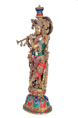 Brass Krishna showpiece side profile, ornate crown, multi-color garments on pedestal, 25 in