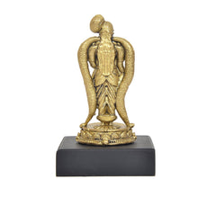 Golden rear view deity idol with crown, hands at hips, on lotus base