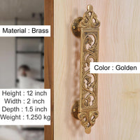 Golden brass door pull handle with ornate filigree flower panel and round backplate