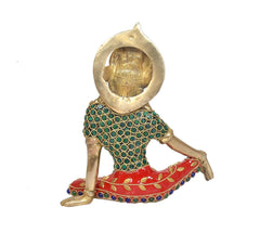 Brass Indra statue from behind, gold headpiece, teal patterned bodice, red jeweled skirt.