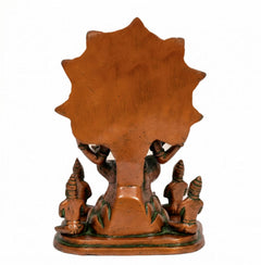 Brass Dakshinamurti Shiva statue back view, orange panel with green base and small idols