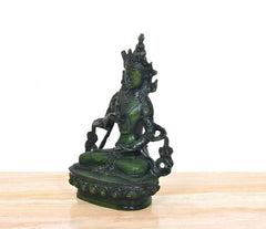 Seitenansicht: Tara Devi Statue im Lotussitz, grüne Patina, rundes Prunkpodest