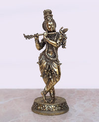 Brass Krishna idol playing flute with ornate crown, detailed dress, round base