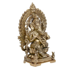 Brass Ganesha statue in profile, seated on lotus with carved halo arch