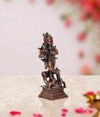 Back view dark bronze Krishna statue with flute and ornate crown, on pedestal base