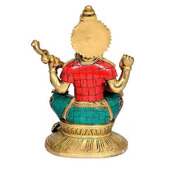 Brass Saraswati murti back view, textured headdress, red top, teal skirt, gold base