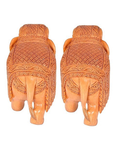 Back view of two small tan wooden elephant statues, carved back patterns