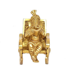 Golden brass Ganesha seated on ornate chair, hands holding book, front view