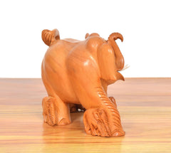 Wooden elephant showpiece from rear-left, brown carved legs and curled tail