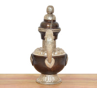 Traditional brass teapot showpiece, front view: dark brown body, chain, and engraved base