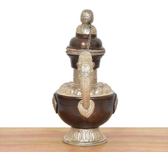 Traditional brass teapot showpiece, front view: dark brown body, chain, and engraved base