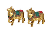 Brass Kamdhenu cow pair wall hanging, side view with red headpiece and green saddle
