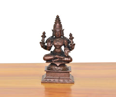 Copper Lakshmi Maa idol, seated figure with raised hands and ornate crown, on pedestal base