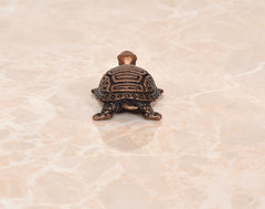 Copper tortoise figurine, rear view with domed shell and small tail