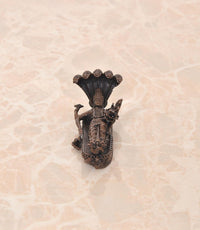 Back view of copper Vishnu-Lakshmi idol on Sheshnag serpent, seated deity figure