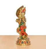 Rear view of Krishna brass idol showing multicolor ornaments on the skirt and base