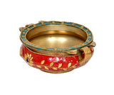 Brass urli with red enamel, gold leaf patterns, blue bead trim, and open gold bowl