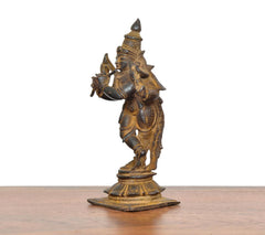 Copper Krishna idol, angled side pose with raised hand and textured base