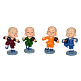 Resin kungfu monk figurines set: maroon, green, orange, blue from side view on bases