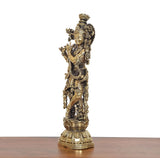 Brass Lord Krishna idol holding flute, angled view with intricate carved jewelry