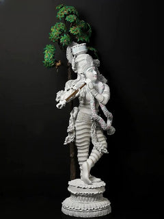 Standing Krishna idol statue with gold flute, white body, garlands, and green tree motif