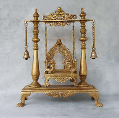 Brass jhula swing front view: ornate arch, chains, and hanging bells