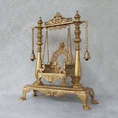 Brass jhula swing side view: turned pillars with bells and carved top bar