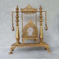 Brass jhula swing with bells, detailed arched back and ornate base on legs