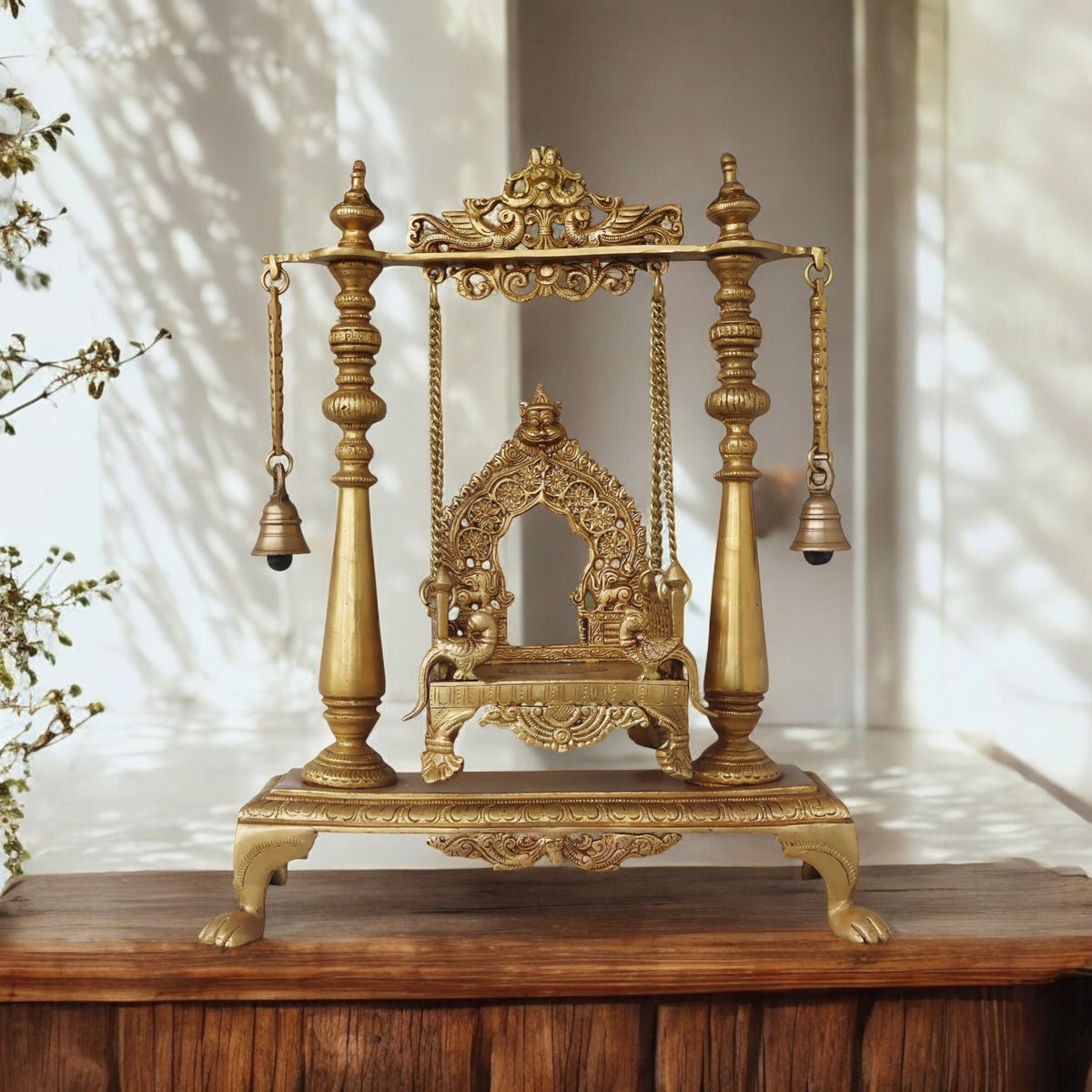 Brass jhula swing with carved frame and hanging bells, four legs