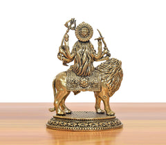 Brass Durga Maa idol on lion from behind, raised arms and ornate back details