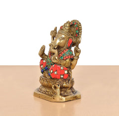Brass Ganesha statue in side profile, jeweled crown, red-and-green patterned attire