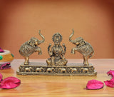 Brass Lakshmi goddess statue seated with two elephants on ornate base.