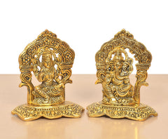 Golden metal Lakshmi and Ganesh statues, front view, detailed arch back and bases