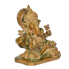 Brass Ganesha idol in side view, four hands and patterned dhoti on pedestal