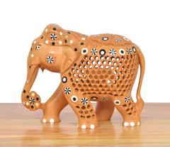 Wooden elephant statue with lattice cut-out body and circular decorative motifs, standing