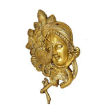 Brass Krishna mask wall hanging shown from the side, with earrings and crown details