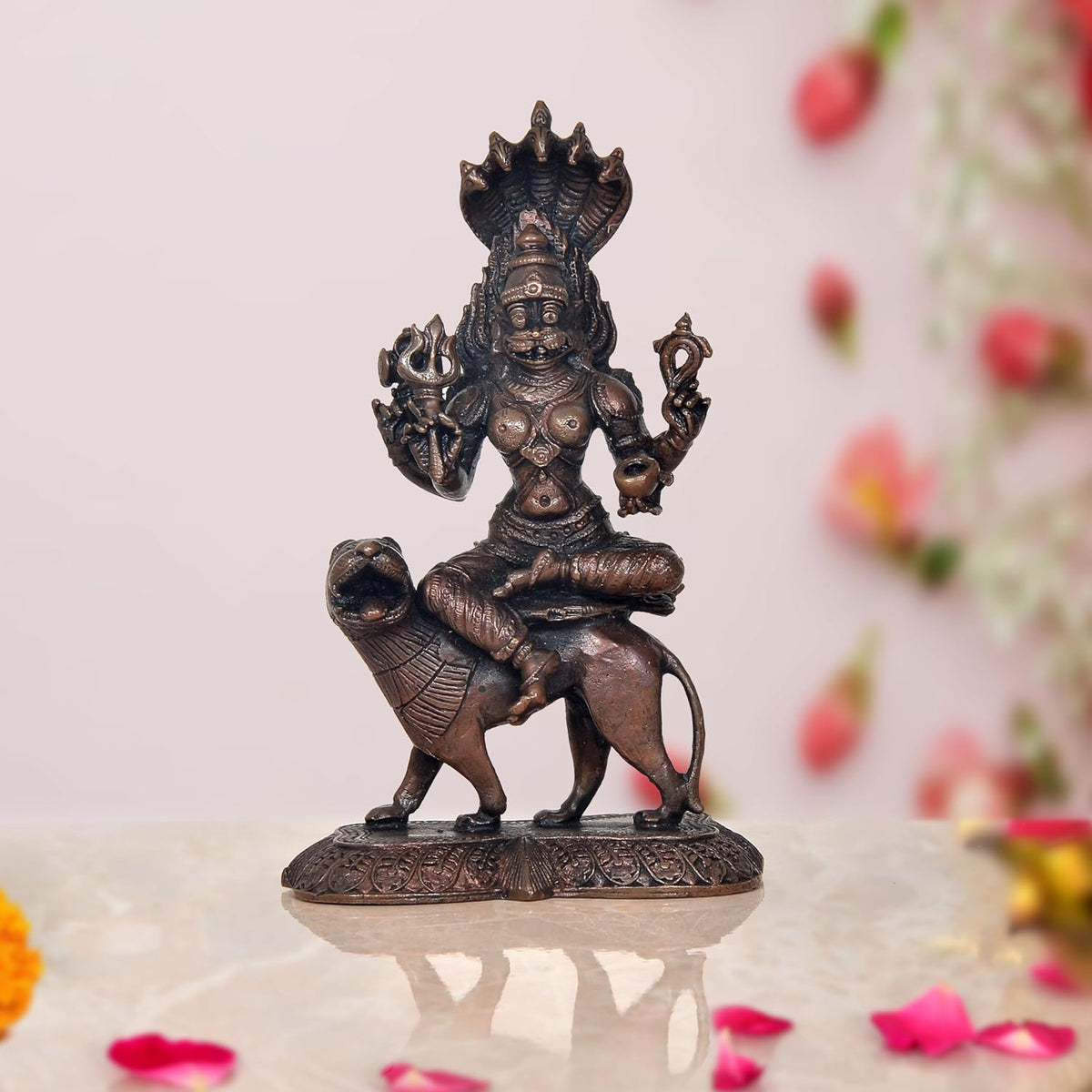 Pratyangira Devi copper statue seated on ornate base, trident and raised hands