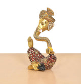 Ganesha brass idol side view with meenakari beaded patterns, blessing hand raised
