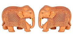 Two small tan wooden elephants, carved patterns, trunk raised, side view
