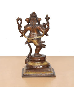 Back view of brass dancing Ganesha murti, carved crown details, pedestal base
