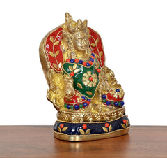 Brass Kubera statue with red halo, green chest panel, blue bead garlands, seated