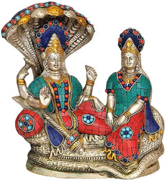 Brass Vishnu Lakshmi idol statue, front view with crown, painted jewelry and teal-red drape