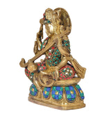 Side view Saraswati idol seated with veena, gold body and multicolour gem-studded dress