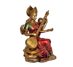 Resin Mata Saraswati idol with veena, gold accents, red sari, seated on decorative base