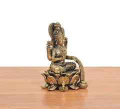 Seated Lakshmi idol with arched back, raised right hand and lotus pedestal